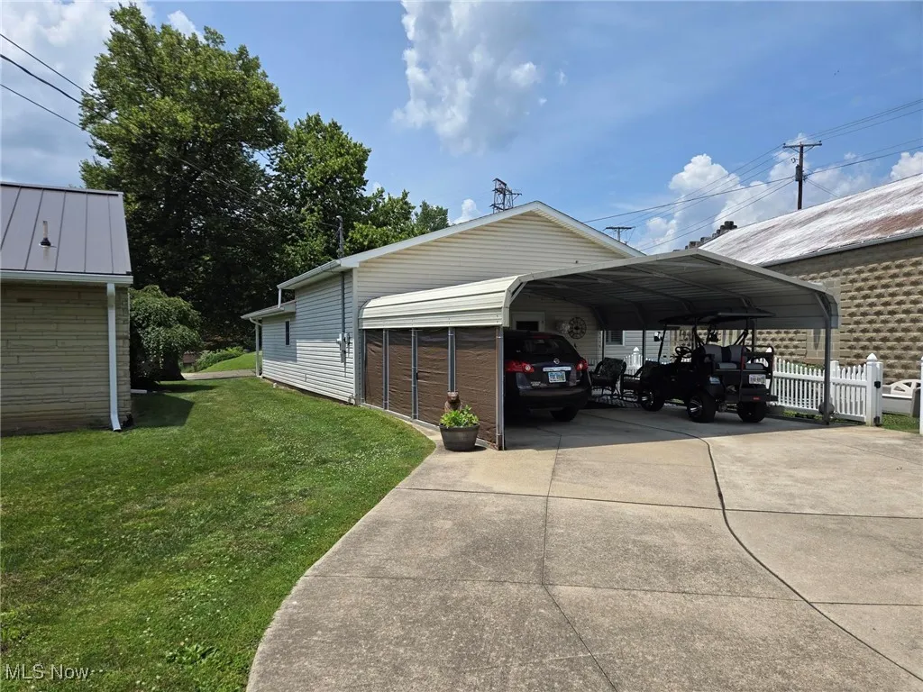 View of parking / parking lot with concrete driveway and a detached carport