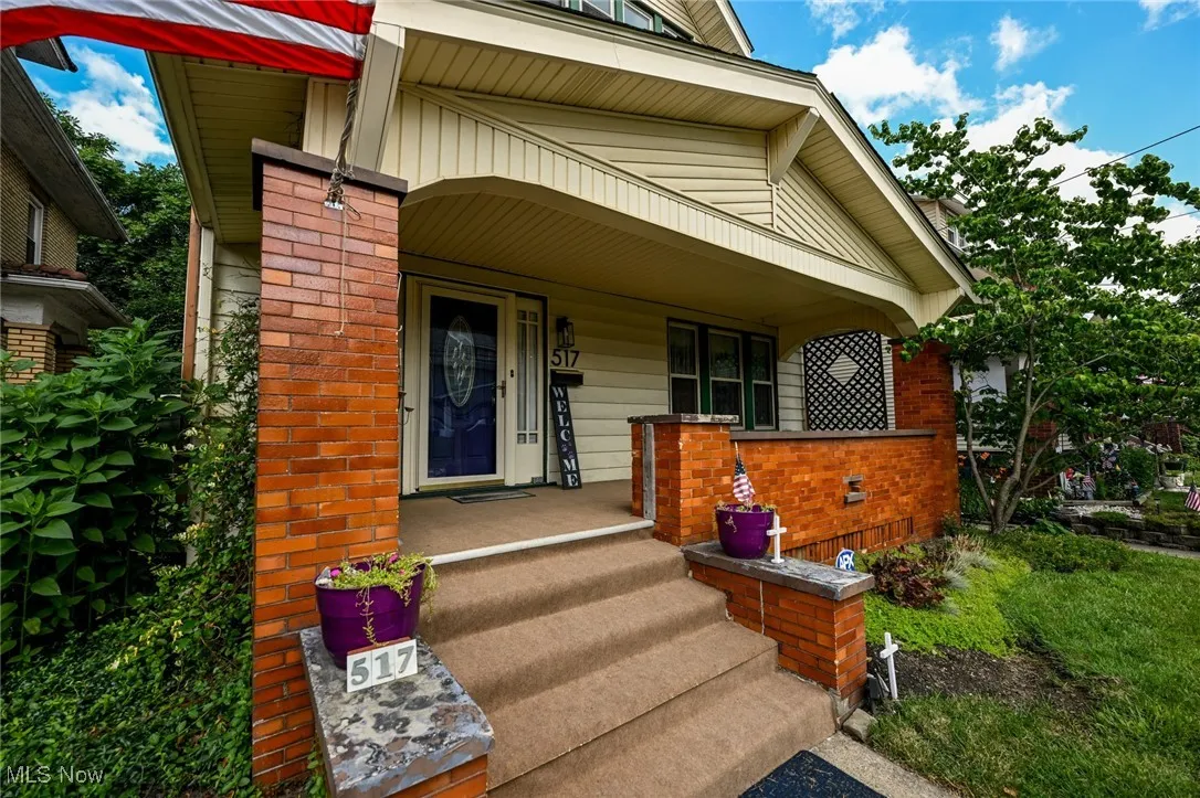 Doorway to property featuring a porch and brick siding