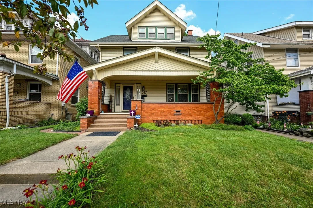 Traditional style home with a front lawn, covered porch, and brick siding