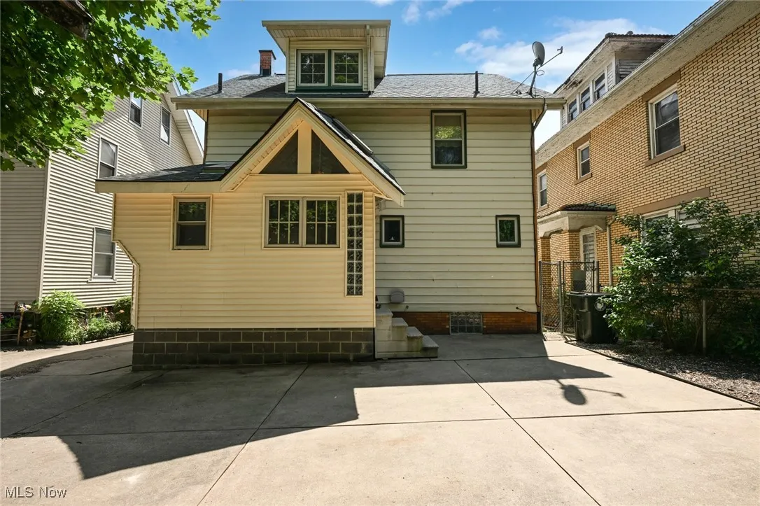 Rear view of house featuring roof with shingles and a patio