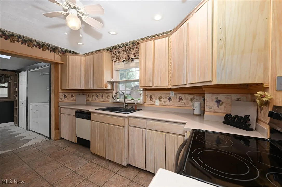 Kitchen with black / electric stove, light brown cabinets, dishwashing machine, light countertops, and recessed lighting