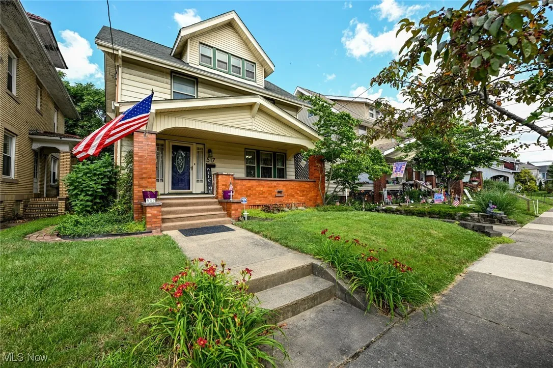 Traditional style home featuring covered porch, a front yard, and brick siding