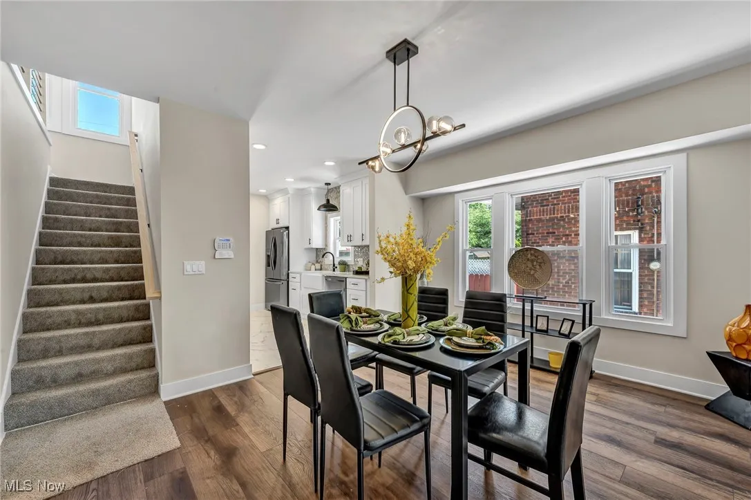Dining space featuring stairway, dark wood-type flooring, recessed lighting, and a chandelier