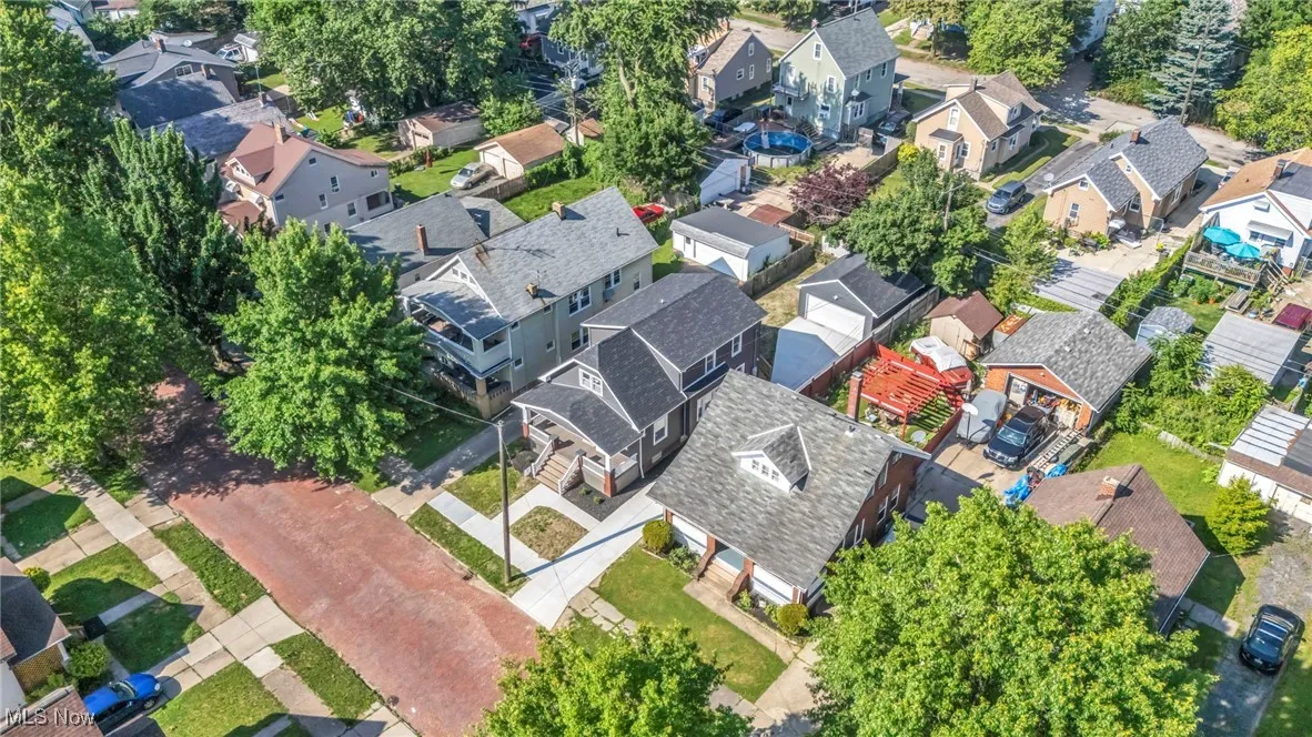 Aerial view of property and surrounding area featuring nearby suburban area