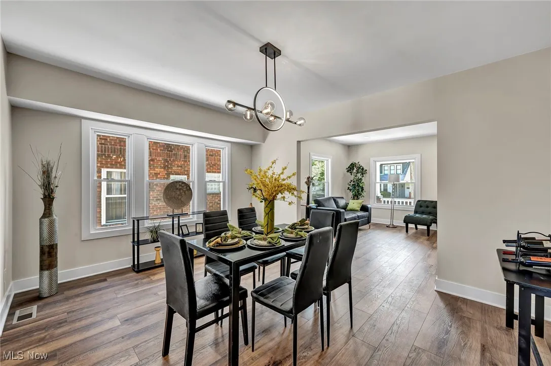 Dining area featuring dark wood-style floors and a chandelier