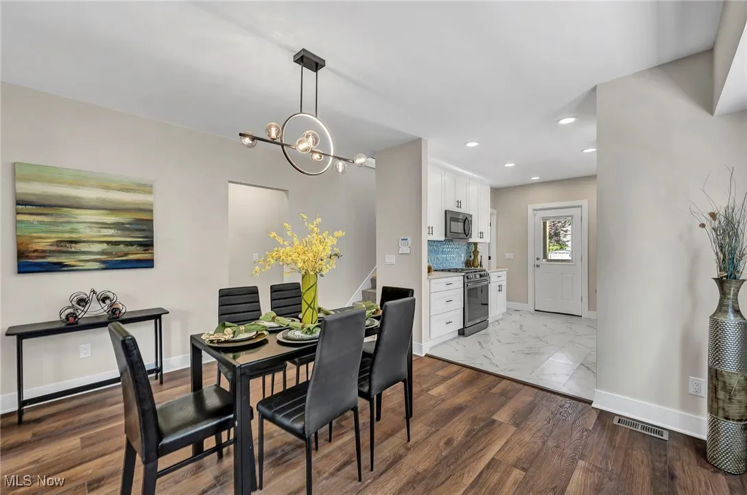 Dining space with recessed lighting, a chandelier, stairs, and dark wood-style flooring