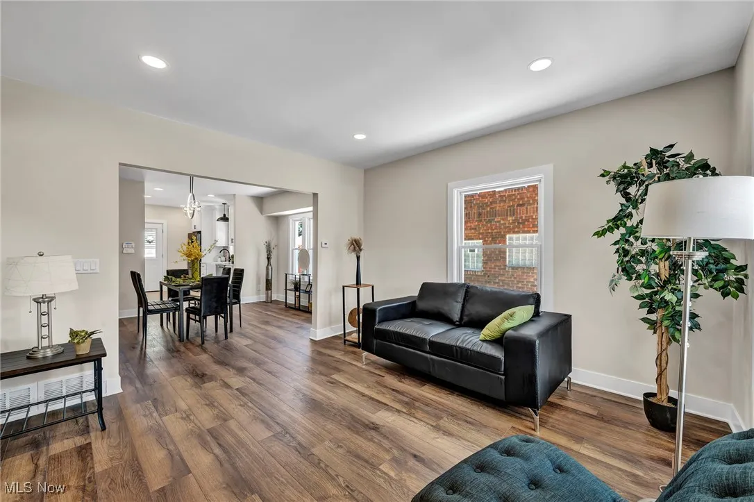 Living area featuring dark wood-type flooring and recessed lighting