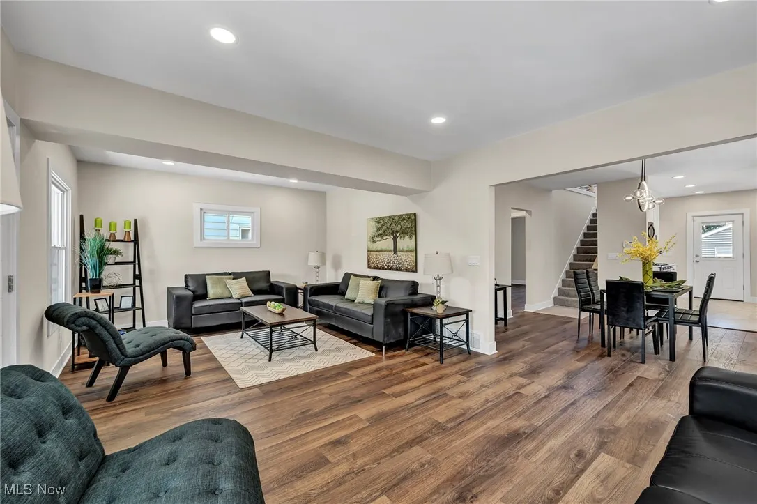 Living area featuring stairs, wood finished floors, and recessed lighting