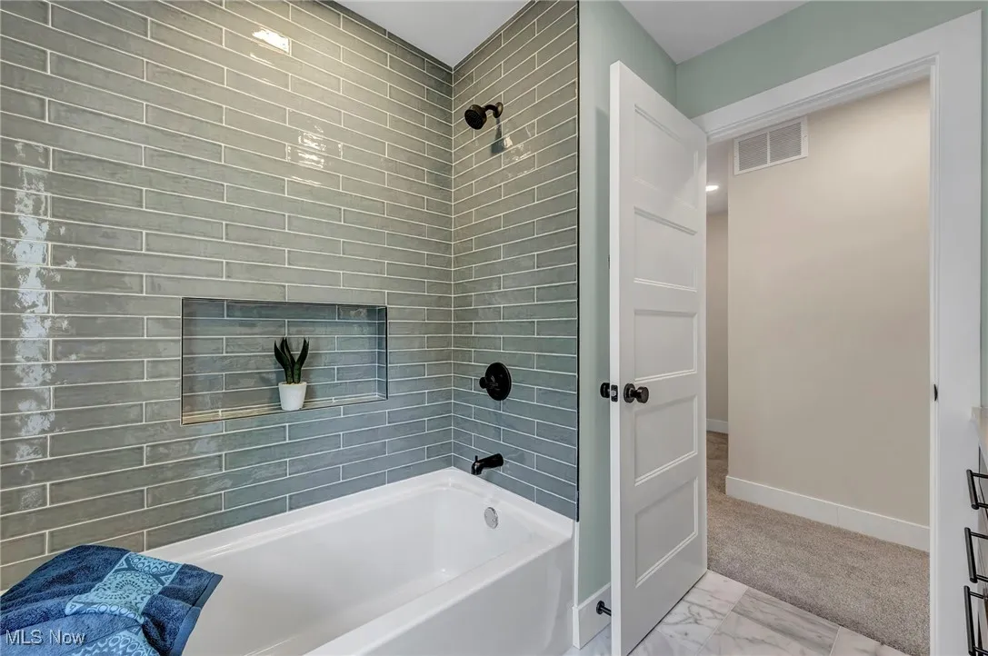 Bathroom with  shower combination and marble look tiles