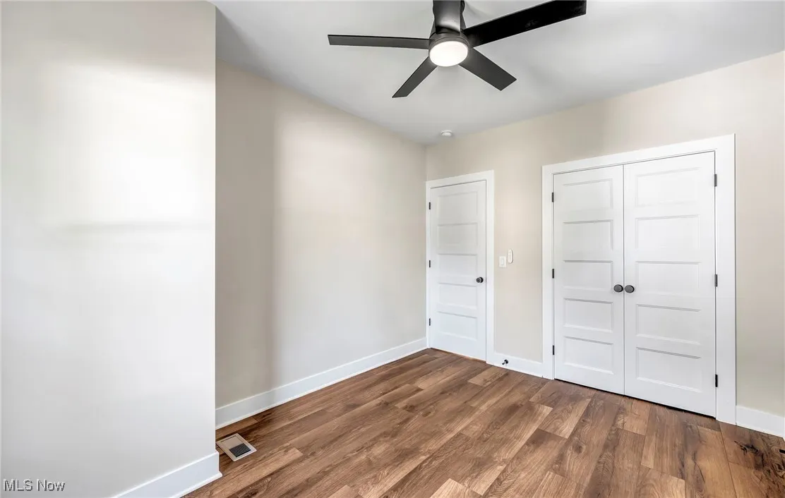 Unfurnished bedroom featuring wood finished floors, a closet, and ceiling fan