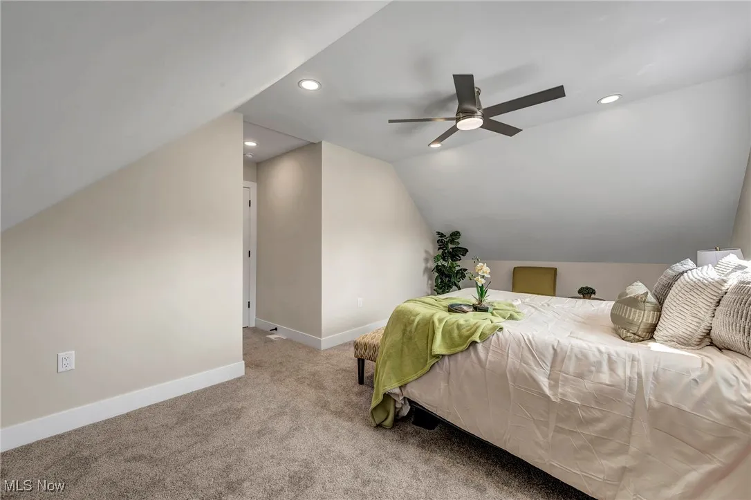 Carpeted bedroom featuring vaulted ceiling, recessed lighting, and a ceiling fan