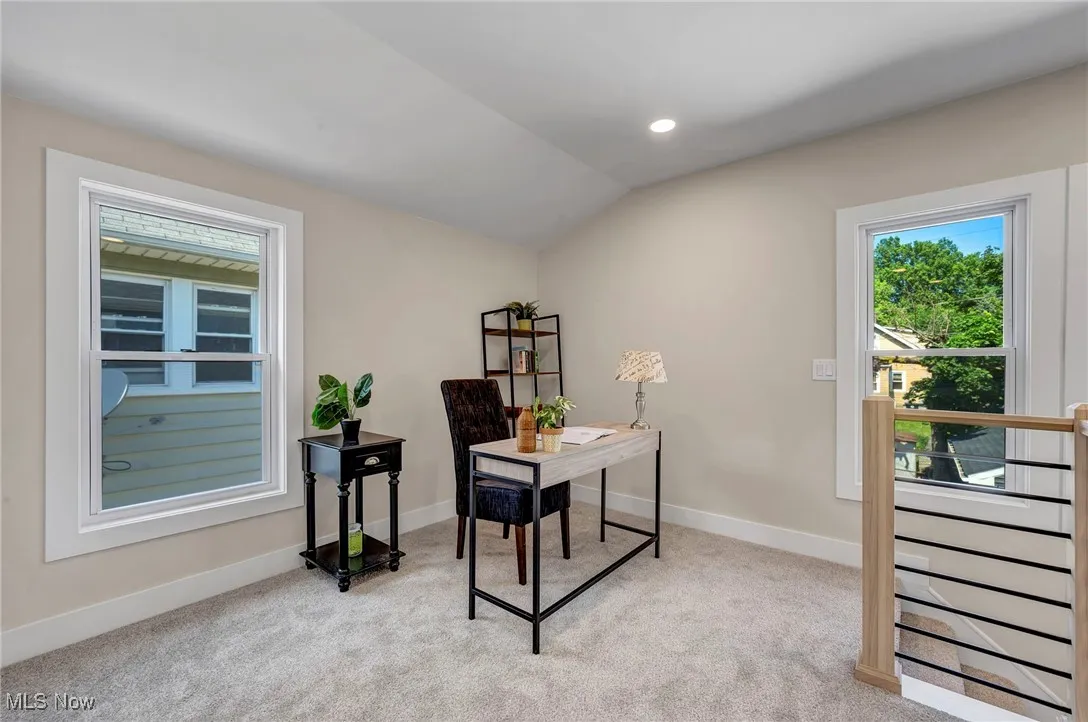 Office space with light colored carpet, vaulted ceiling, and recessed lighting
