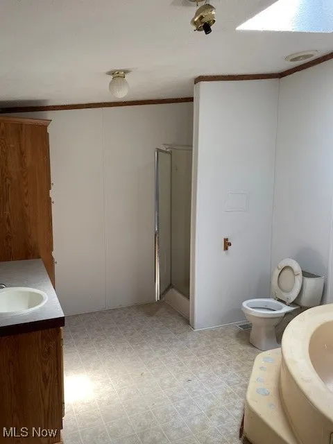 Full bath with crown molding, vanity, a shower stall, a bath, and tile patterned floors
