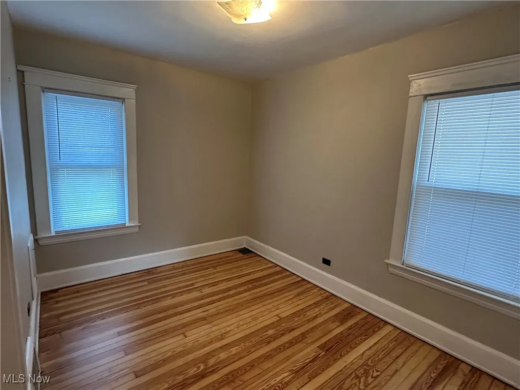 Unfurnished room featuring wood finished floors and baseboards