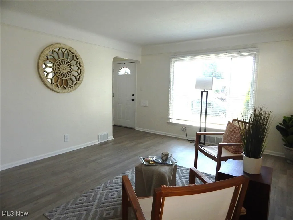 Spacious Living area with arched Foyer and wood look Lux Vinyl tiled floors, updated Windows & Plantation Blinds.