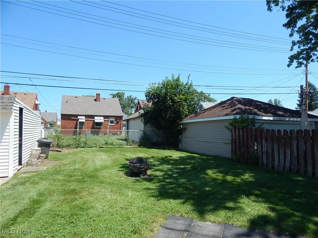 Fenced backyard with a fire pit