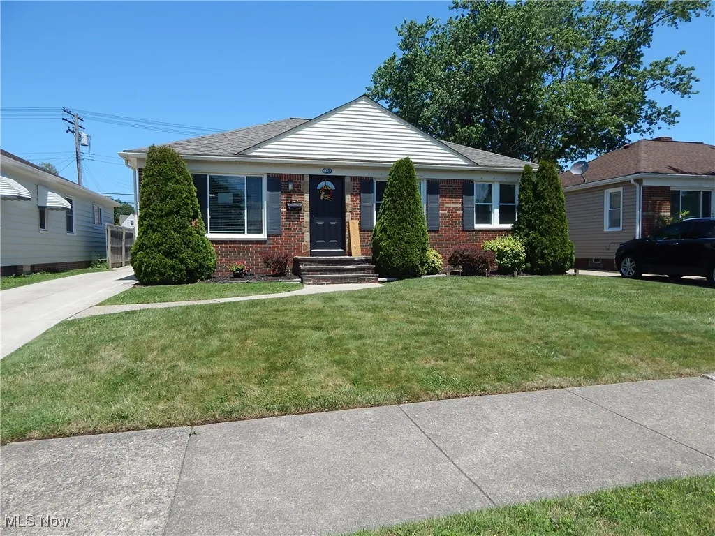 View of front facade with brick front, vinyl siding and a front lawn