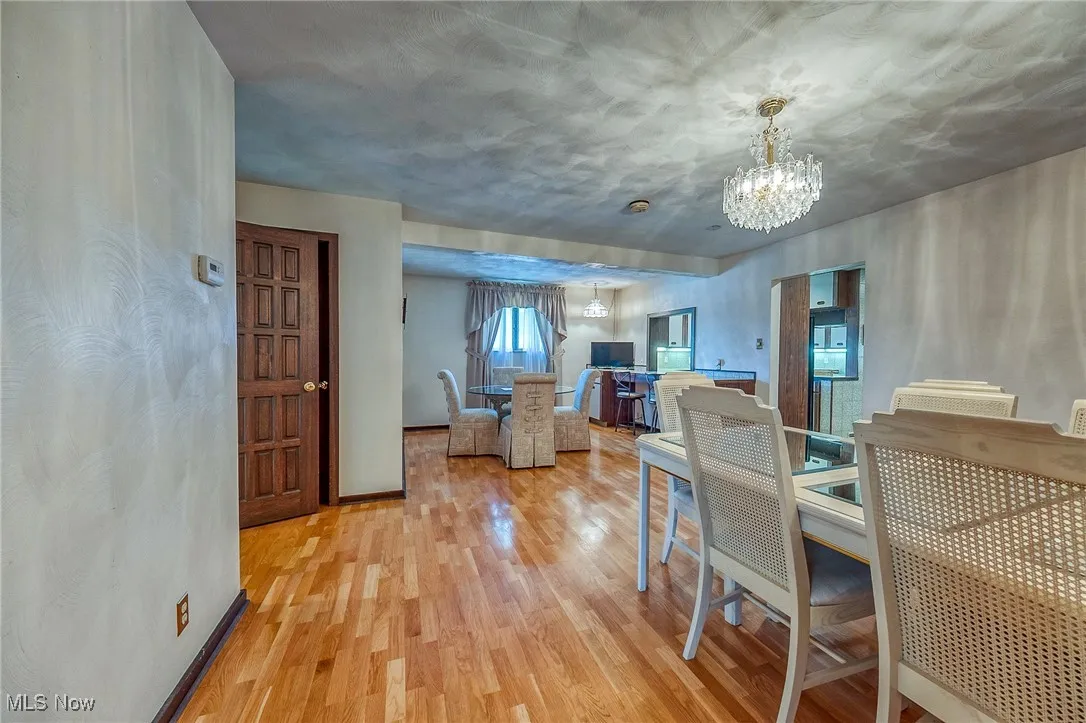 Dining area with wood finished floors and a chandelier