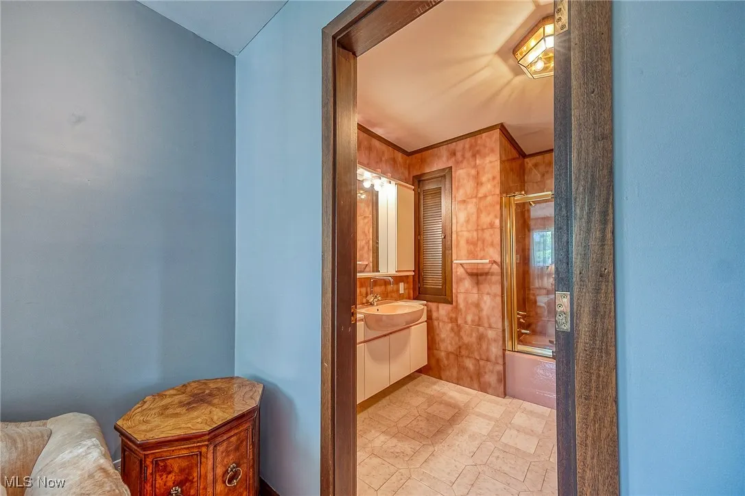 Bathroom with vanity and shower / bath combination with glass door