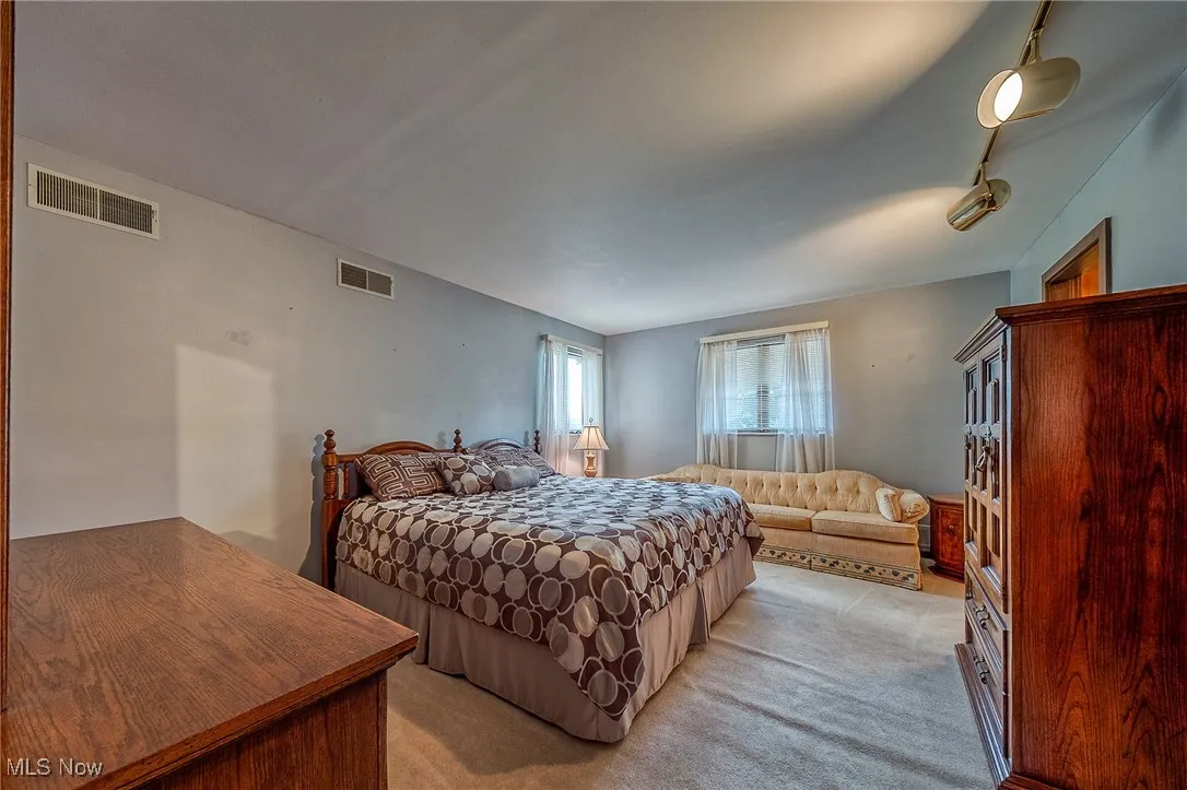 Bedroom featuring light carpet