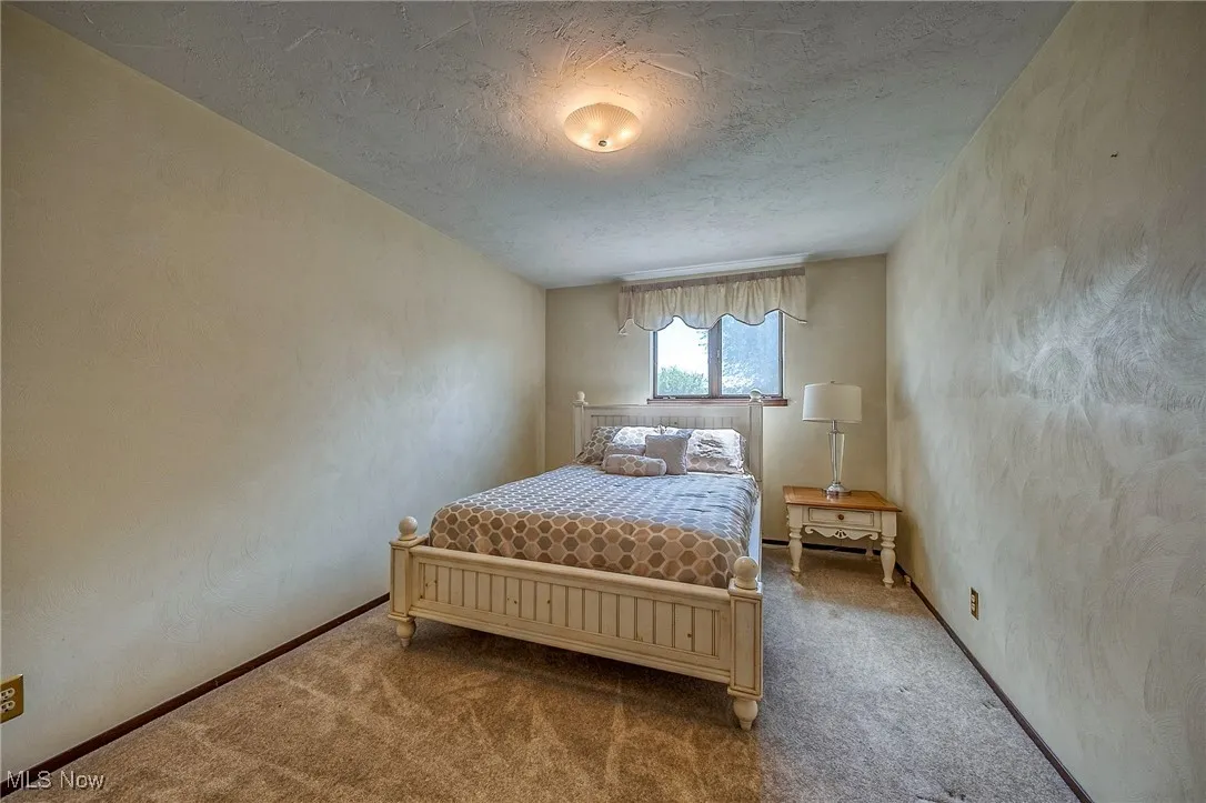 Carpeted bedroom featuring a textured ceiling