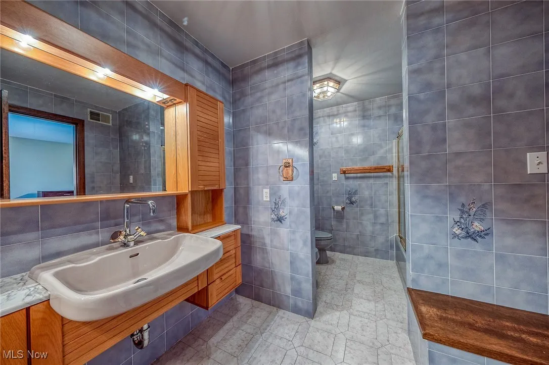 Full bath with bath / shower combo with glass door and toilet