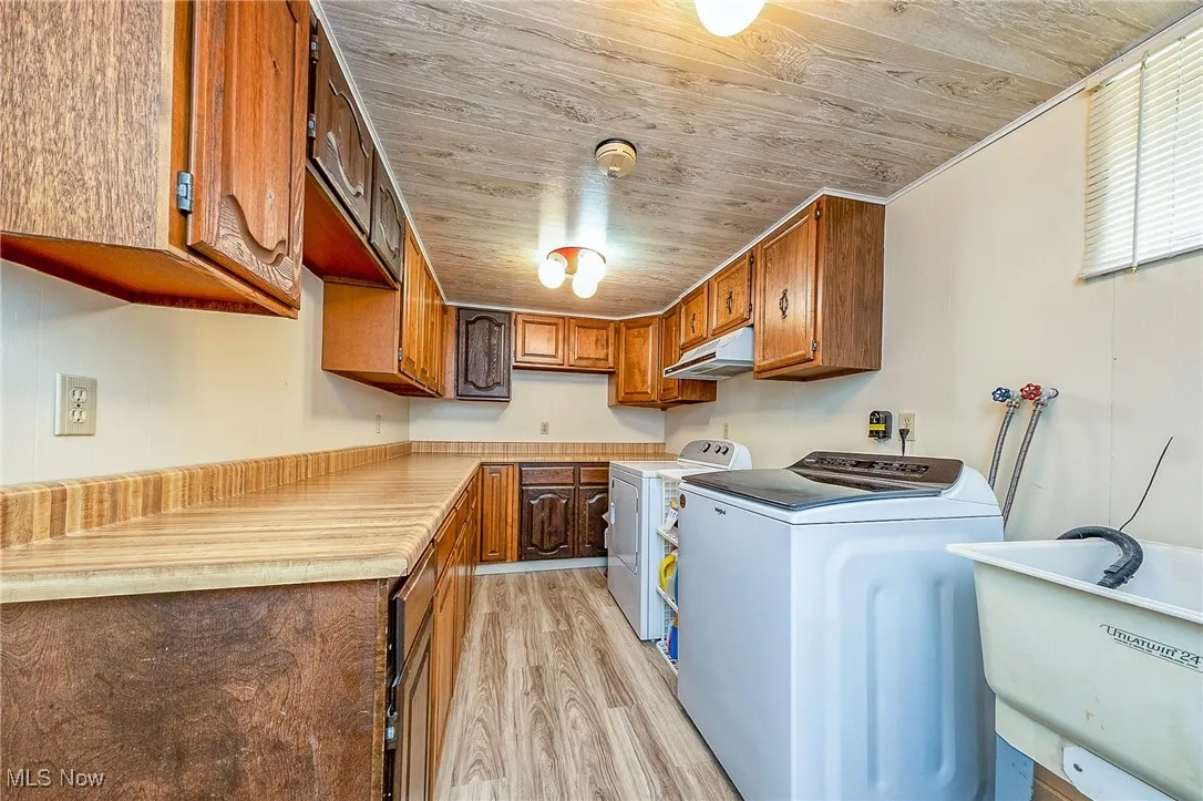 Laundry area featuring cabinet space, light wood finished floors, wooden ceiling
Washer and Dryer do not stay