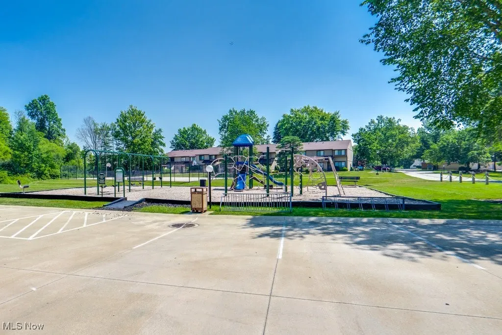 Surrounding community with a yard and uncovered parking