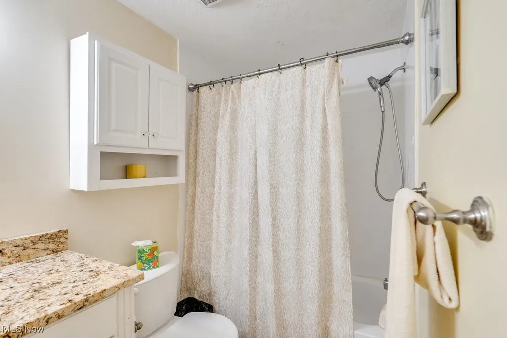 Bathroom with vanity and shower / bathtub combination with curtain