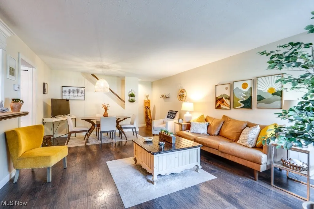 Living room featuring dark wood-style floors and baseboards
