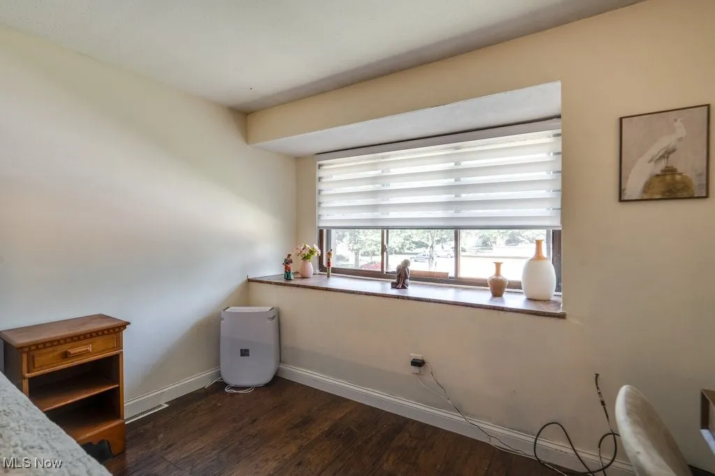 Bedroom featuring dark wood-style floors and baseboards
