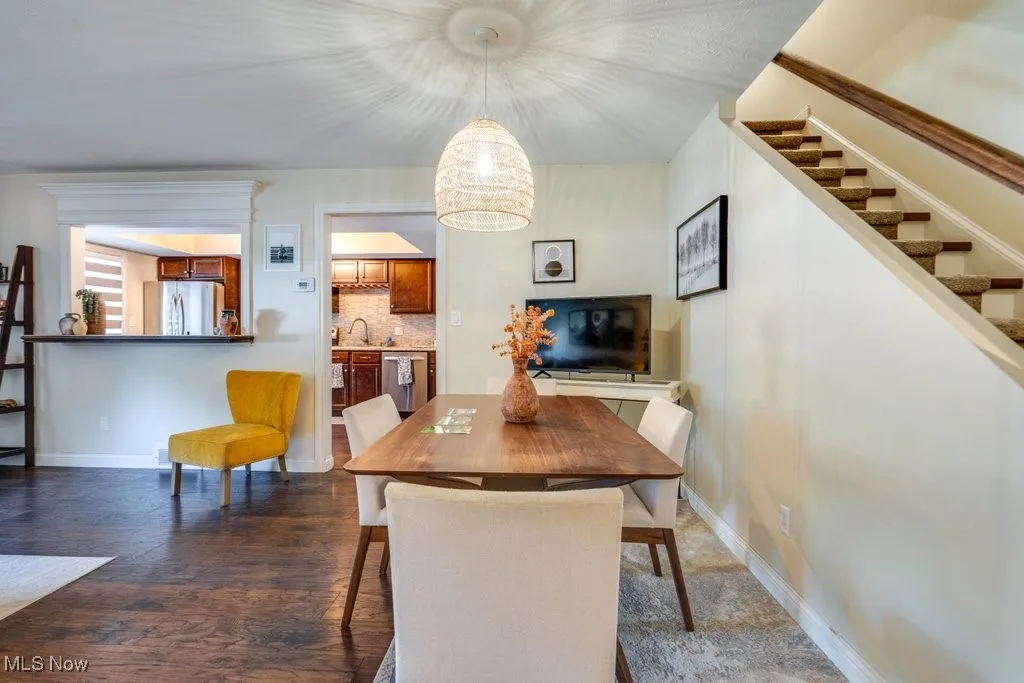 Dining area with stairs and dark wood finished floors