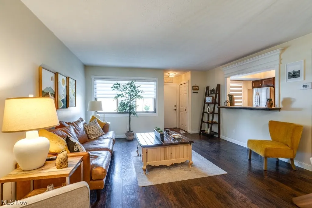 Living room with dark wood-style floors and baseboards