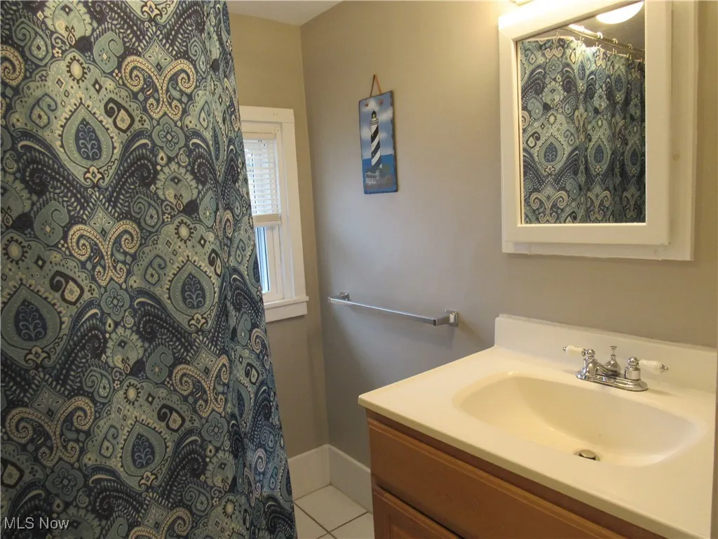 Full bathroom boasts ceramic tiled flooring, towel bar, clawfoot soaking tub/shower, vanity & medicine cabinet!