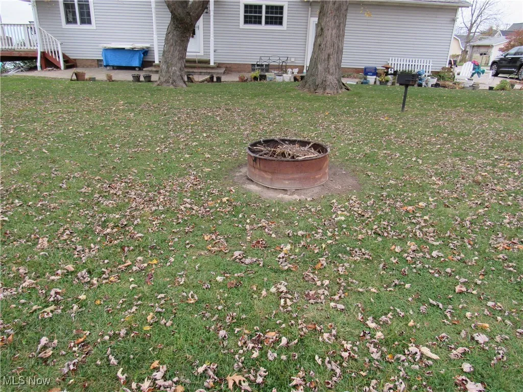 View of yard featuring an outdoor fire pit!