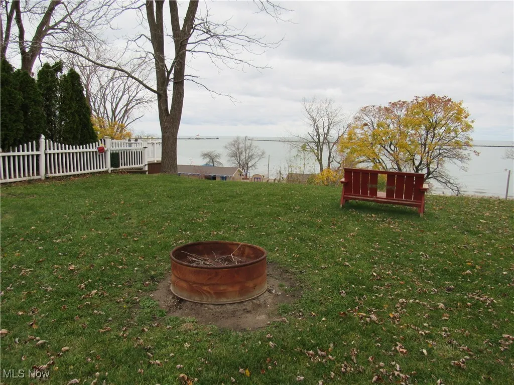 View of yard with a fire pit & cozy chair to enjoy th Lake Erie views!