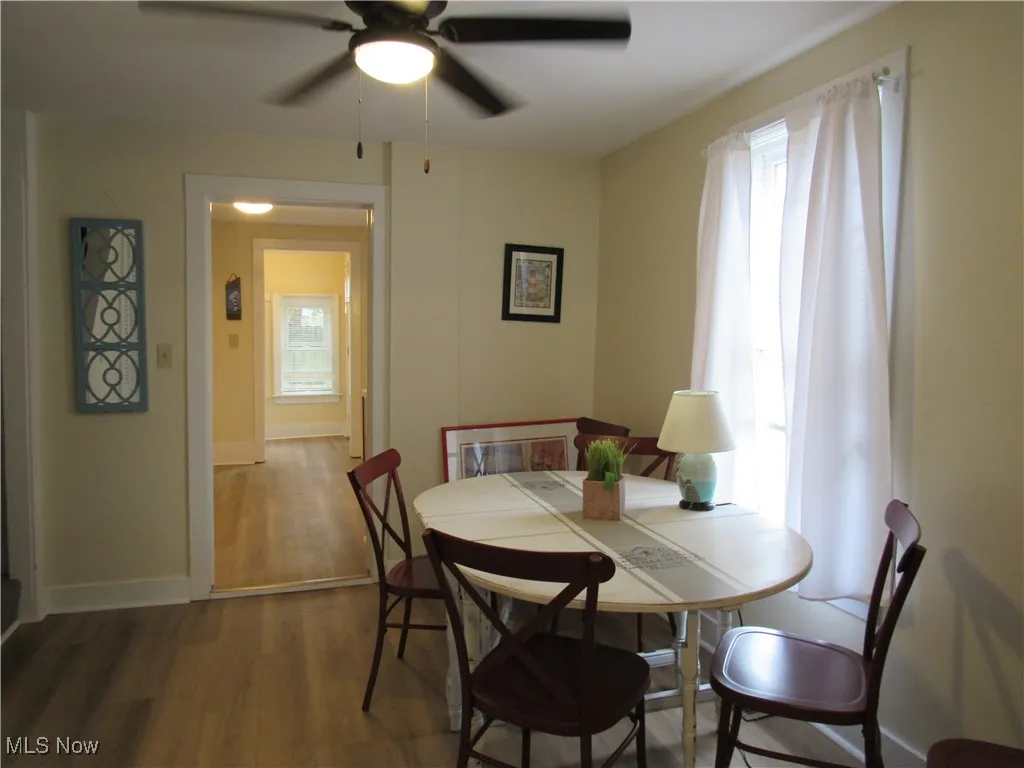 Neutral dining room with newer LTV flooring, ceiling fan & window treatments!