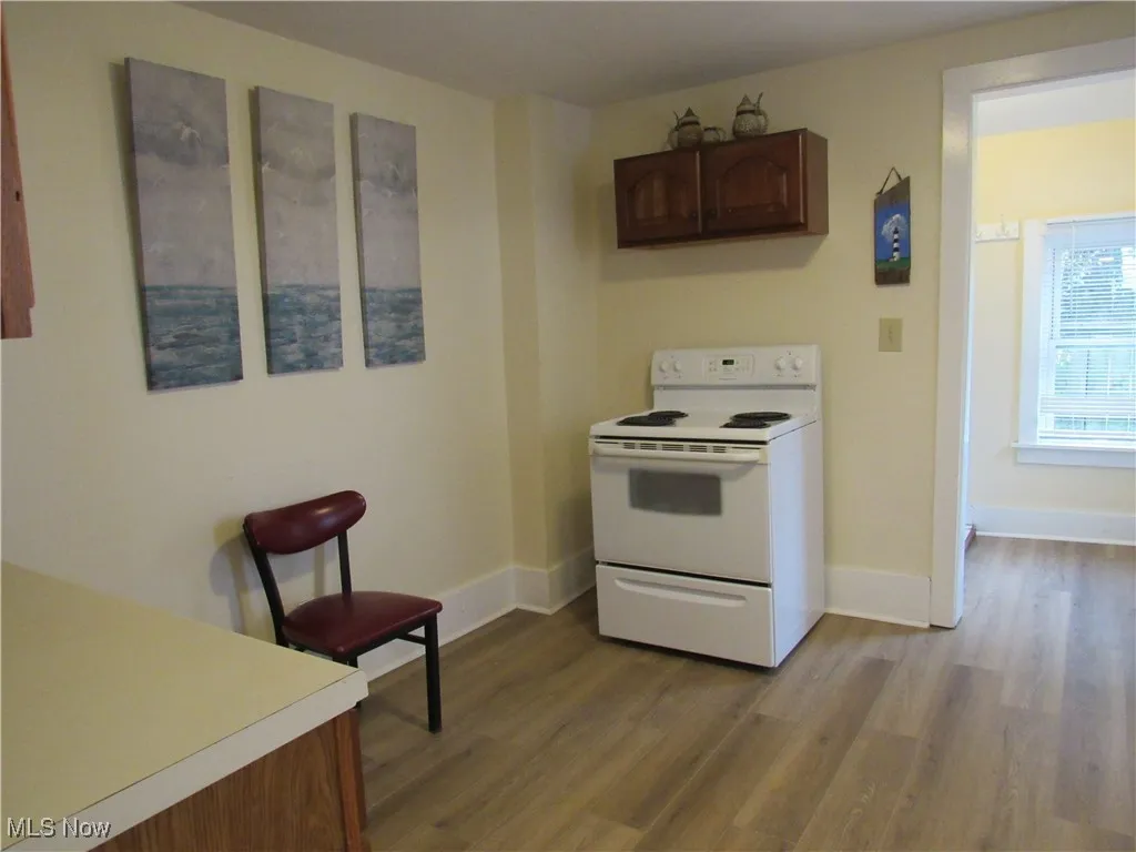 Spacious kitchen boasts a neutral decor, range, cabinetry, and newer LTV flooring into the laundry room!