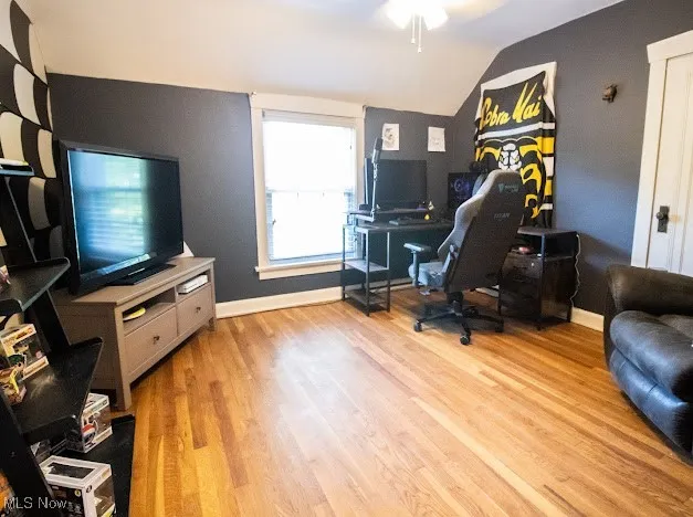 Home office featuring vaulted ceiling, light wood finished floors, and ceiling fan