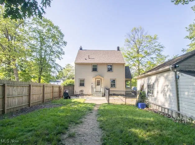 Back of house with entry steps, a fenced backyard, and a patio area