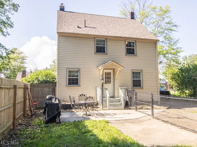 Back of property featuring a gate, a fenced backyard, a chimney, and a patio