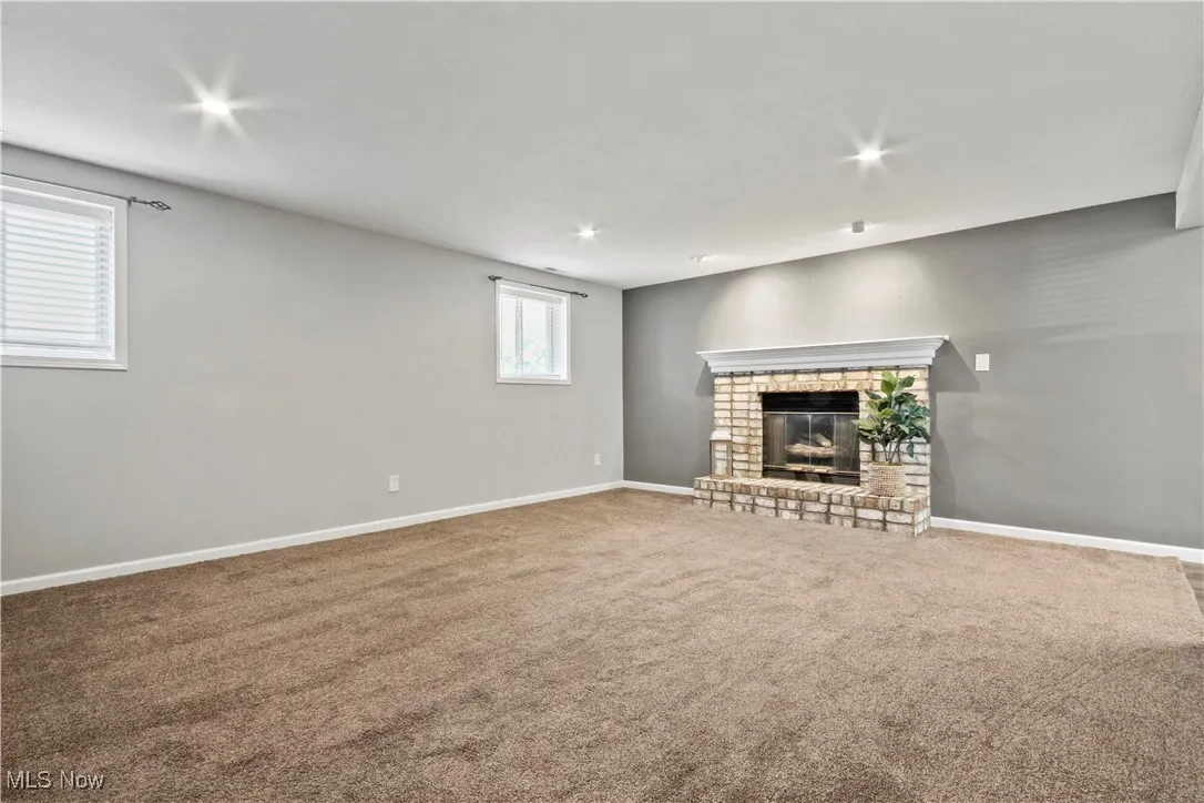 Unfurnished living room with carpet, a fireplace, and recessed lighting