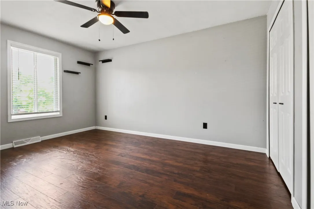Unfurnished bedroom with a closet, wood finished floors, and ceiling fan