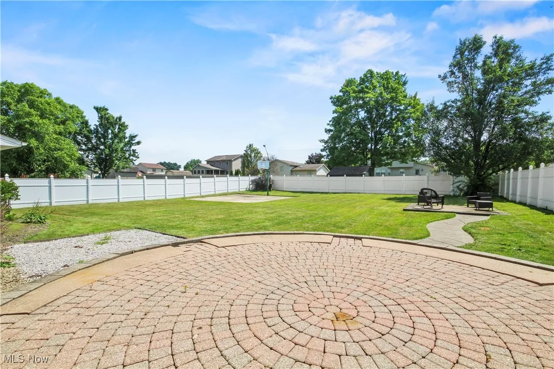 Fenced backyard with a patio area and a fire pit