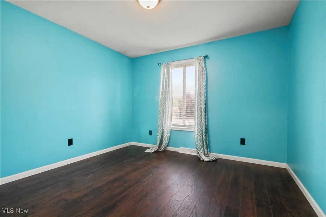 Spare room with wood finished floors and baseboards