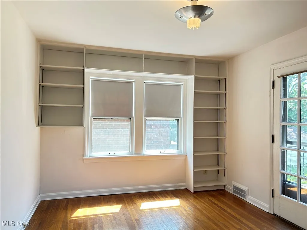 Third bedroom with built-in shelves and access to balcony