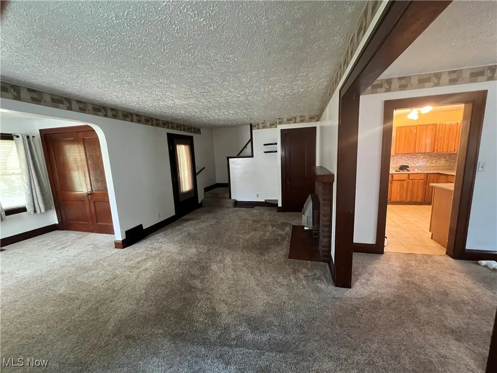  living room featuring a textured ceiling, carpet flooring,fp