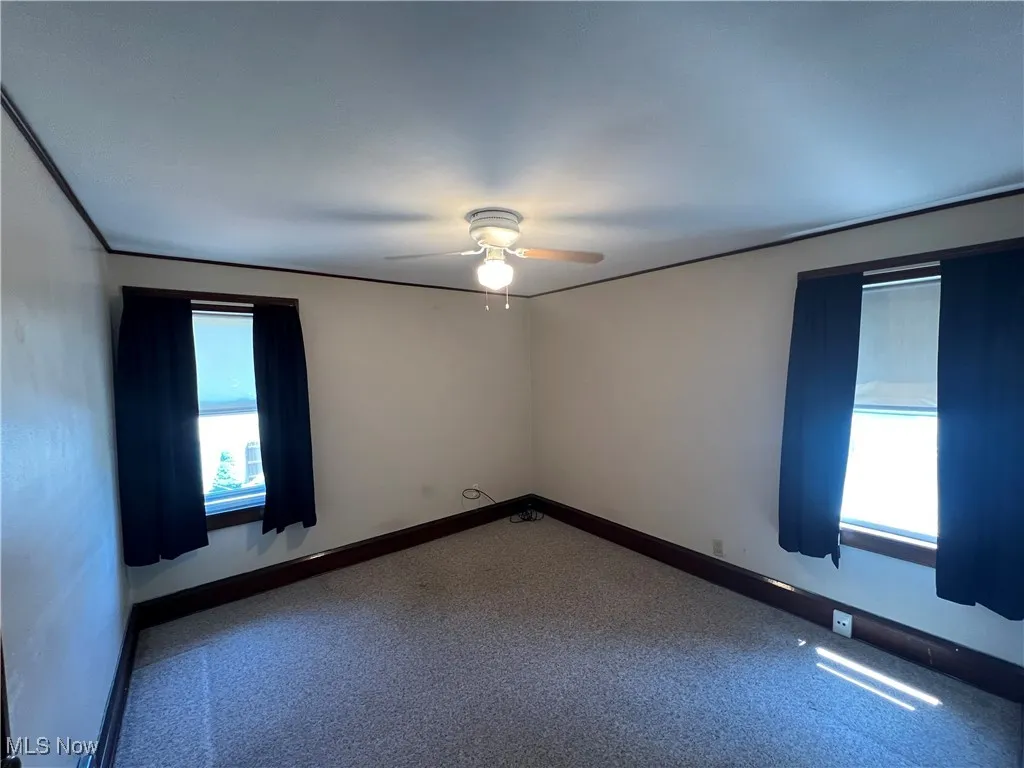 Carpeted BR room with ceiling fan and baseboards