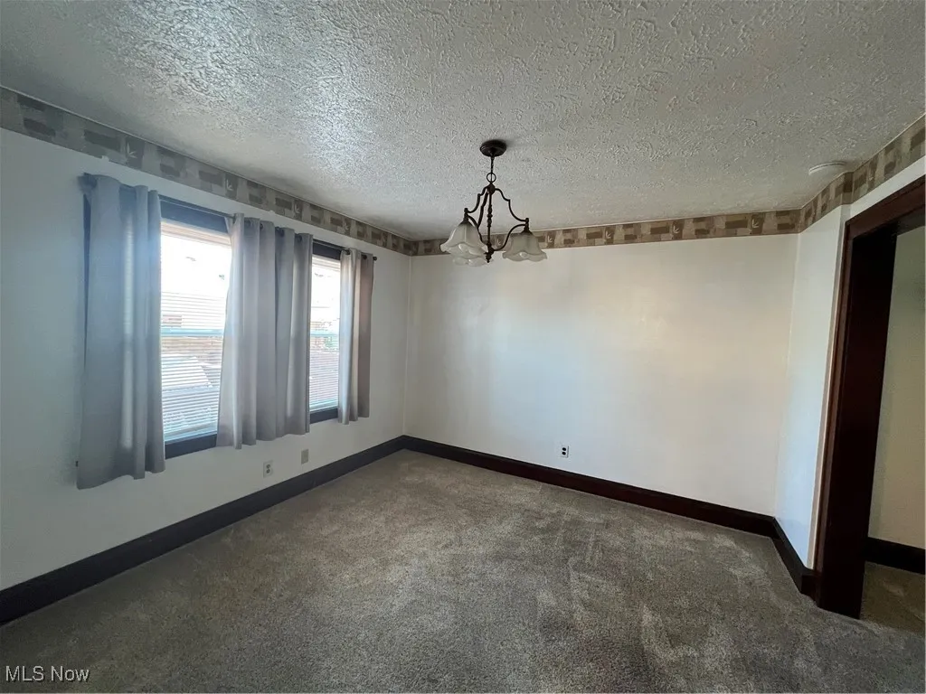 DR featuring carpet, a chandelier, and a textured ceiling