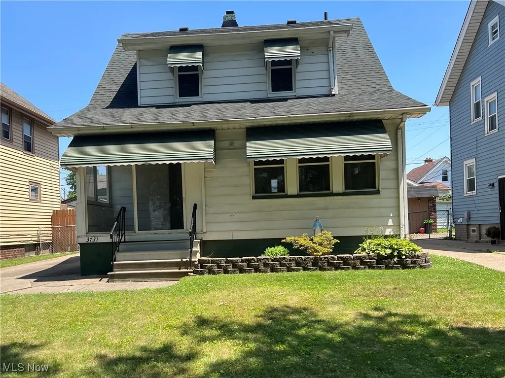 Bungalow-style home with a front lawn and a shingled roof